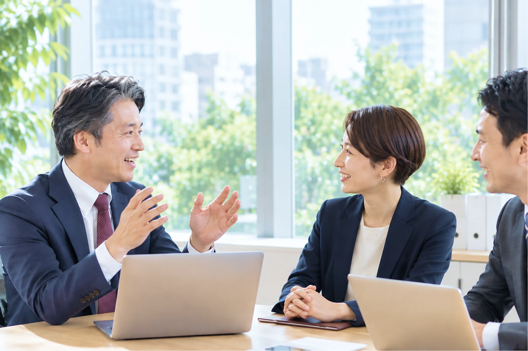 明るいオフィスで対話する経営者と仲間